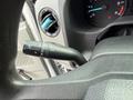 Close-up of the control stalk in a 2022 Ford E-450 showing the wiper and headlight controls with a textured grip and dashboard instrument cluster in the background