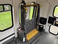 A wheelchair lift in a 2009 Ford Econoline with a yellow platform and metallic frame positioned inside the vehicle