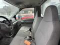A gray interior of a 2004 Ford F-350 SD featuring two front seats and a dashboard with controls and a rearview mirror
