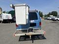 A blue 2005 Ford Econoline van with a utility lift and a white metal storage box mounted on the back