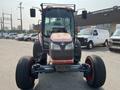 A 2010 Kubota M6040 tractor features a front view with a cab, large tires, and a distinctive Kubota logo on the hood