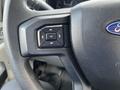 Close-up of a steering wheel button cluster in a 2017 Ford F-250 SD featuring navigation controls and an OK button