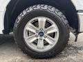 A close-up of a silver alloy wheel on a 2017 Ford F-150 with a rugged all-terrain tire featuring deep treads
