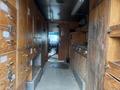 The interior of a 2012 Workhorse W62 featuring wooden cabinets on either side and a view of the driver's seat near the front