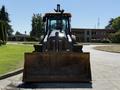 A 2013 John Deere 710K tractor with a large front loader bucket positioned on the ground facing forward