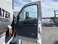 A 2015 Ford F-750 truck with an open driver's side door showcasing the interior panel and controls