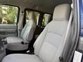 Interior of a 2011 Ford Econoline featuring two front seats with gray upholstery and a minimalistic dashboard design