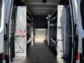 Interior of a 2023 Mercedes-Benz Sprinter 2500 with shelving units on both sides and open space in the center for cargo storage