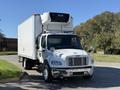 A 2017 Freightliner M2 106 truck with a white box body and refrigeration unit on top, featuring chrome front accents and side mirrors
