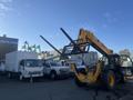 A yellow 2013 JCB 510-56 Loadall with a telescopic arm and forks attached positioned in the foreground, showcasing its heavy machinery design and capabilities