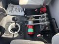 An interior view of a 2014 Freightliner M2 106 showing the gear shifter emergency brake levers and a fire extinguisher on the cabin floor