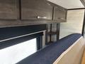 Interior view of a 2021 Jayco Jay Flight showing cabinets and a sofa with a blue cushion