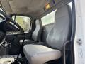 Interior of a 2014 Freightliner M2 106 showing two gray vinyl seats and a simple dashboard with gear shift and controls