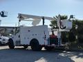 White 2006 Freightliner M2 106 bucket truck with a raised aerial lift and utility storage compartments on the side