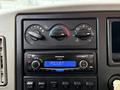 Dashboard controls of a 2012 International 7400 featuring climate control knobs and a Panasonic car stereo with an adjustable display