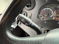 Close-up of the steering wheel and dashboard controls of a 2012 Ford Econoline showing the wiper and headlight control stalk and the speedometer