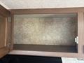 An empty wooden cabinet with a light-colored interior and a smooth shelf