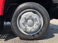 Close-up of a silver wheel with gray hub and lug nuts mounted on a black tire labeled Toyo 25770R195