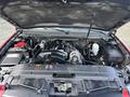 The image shows the engine compartment of a 2011 Chevrolet Avalanche with visible components like the engine, battery, and various fluid reservoirs