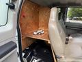 The interior of a 2008 Ford F-450 SD features leather seats with a wooden panel behind them and hooks for storage