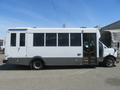 A 2020 Chevrolet Express bus with a white and gray exterior features large windows and a door on the side for passenger access