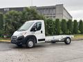 A 2023 RAM Promaster 3500 chassis cab in white with a flatbed design and visible truck features such as wheels and a front grille