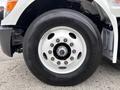 Close-up of the wheel of a 2025 Peterbilt 536 featuring a silver rim with multiple bolt holes and a black tire with tread visible
