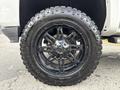 A black alloy wheel with a rugged tire mounted on a 2017 Chevrolet Silverado 1500 showcasing its stylish design and off-road capabilities