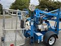 A 2016 Genie TZ-34/20 aerial lift machine featuring a basket with a guardrail on a wheeled base and control panel with various buttons and switches