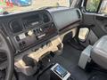 Interior view of a 2010 Freightliner M2 106 dashboard featuring controls, gauges, and a radio system