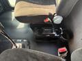 Interior view of a 2008 Peterbilt 340 showing the driver's seat gear shift lever and a center console with cup holders and storage compartments