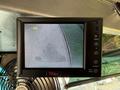 A monitor displaying a camera view of a parking area showing gravel and asphalt from the perspective of a 2017 Freightliner MT45 vehicle