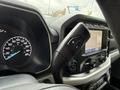Dashboard of a 2021 Ford F-150 displaying speedometer and infotainment screen with various controls and a gear shift lever
