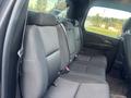 Interior view of the back seat of a 2011 Chevrolet Avalanche featuring dark fabric upholstery and seat belts visible on each side