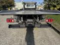 Rear view of a 2022 Freightliner M2 106 with taillights and a flatbed attachment visible