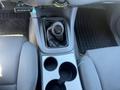 Interior view of a 2010 Toyota Tacoma showing the gear shift knob leather boot and console with cup holders