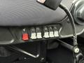 Close-up of control switches on a 2013 International Durastar 4300 dashboard featuring red and gray toggle switches for various functions