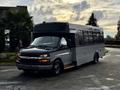 A 2019 Chevrolet Express bus is parked with a two-tone black and gray exterior and large windows along the side