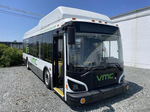 A 2017 Grande West Vicinity bus with a white and black exterior featuring green branding on the front and side
