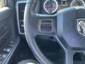 Close-up of the steering wheel of a 2015 RAM 1500 featuring control buttons and a textured grip