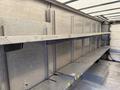 A 2012 Ford Econoline with metal shelving installed in the cargo area featuring multiple horizontal racks for storage and no visible cargo present