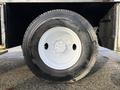 Close-up of a black tire mounted on a white rim belonging to a 2010 International 4300 showing tread pattern and wheel details