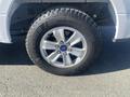 Close-up of a silver alloy wheel mounted on a tire with rugged tread pattern designed for all-terrain use on a 2017 Ford F-150