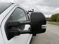 2020 Ford F-550 side mirror showcasing a large black mirror housing with integrated light and adjustable features