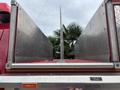 The image shows the rear of a 2002 GMC C7500 with a metal bed featuring a central stake pocket and a reflective strip along the edge