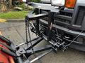 A 2009 Ford F-550 equipped with a snow plow attachment featuring metal chains and hydraulic lift components