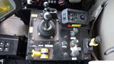 A control panel featuring various levers buttons and switches including a joystick and toggles labeled with different functions