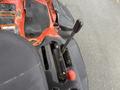 Close-up of the control panel of a 2015 Kubota F3990 featuring a gear shift lever and a red knob among various controls