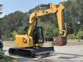 A 2018 Caterpillar 308E2 excavator with a yellow body and black tracks featuring a bucket attached at the end of its arm