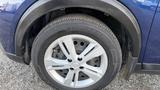 Close-up of a silver alloy wheel of a 2019 Nissan Kicks with a black tire featuring a tread pattern visible on the surface
